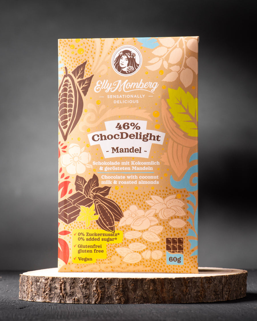 46 % Schokoladentafel ChocDelight mit Mandeln, ohne Zuckerzusatz und vegan von Elly Momberg, zeigt Verpackung auf Holzuntersetzer