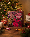 Adventskalender mit 24 Überraschungen und ein Türchen zum öffnen für jeden Tag. Mit Weihnachtsbaum im Hintergrund. 