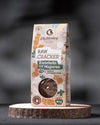 Package of raw crackers with herbs on a dark background