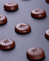 Chocolate candies with star-shaped embossing on a dark surface