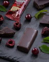 Chocolate gourmet bar with a cross-section on a dark surface with cherry black forest, sugar free, vegan, gluten free, keto. lower carb, diabetics