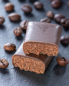 Chocolate bar with a cross-section on a dark surface with coffee beans, sugar free, vegan, gluten free, keto. lowert carb, diabetics