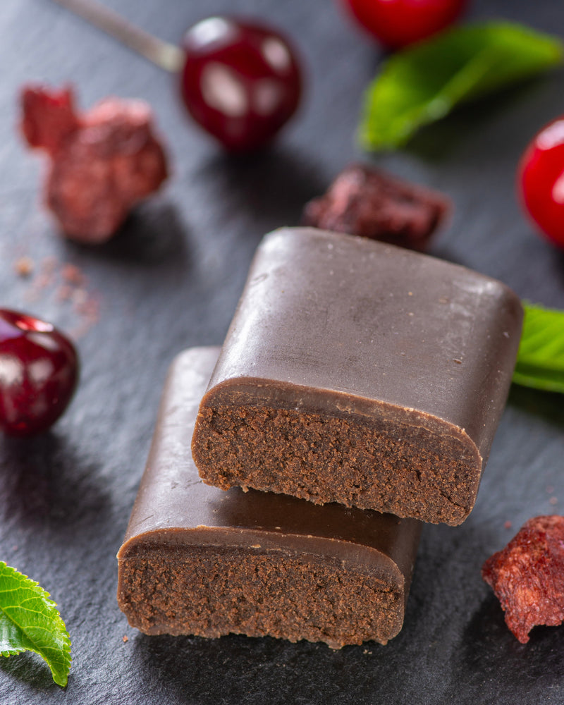 Chocolate gourmet bar with a cross-section on a dark surface with cherry black forest, sugar free, vegan, gluten free, keto. lower carb, diabetics