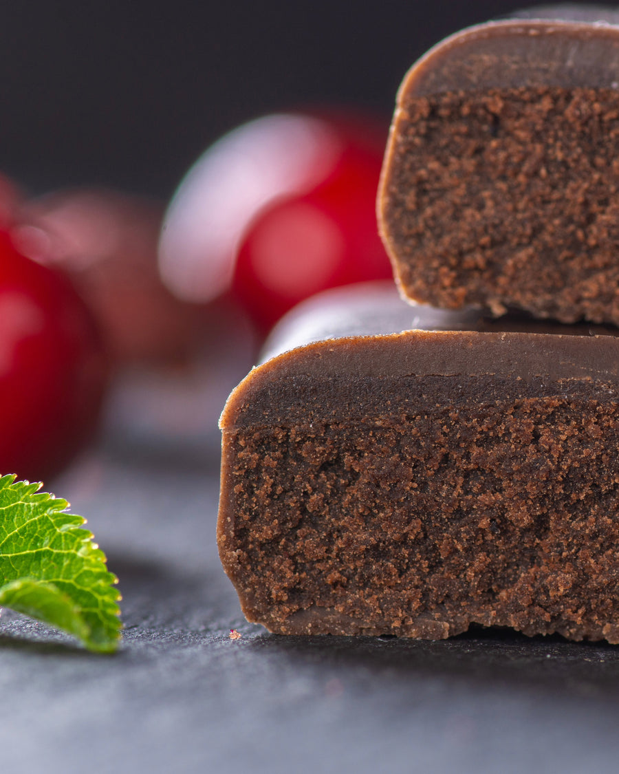 Chocolate gourmet bar with a cross-section on a dark surface with cherry black forest, sugar free, vegan, gluten free, keto. lower carb, diabetics
