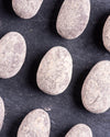 chocolate covered almonds with cinnamon dust on a dark surface