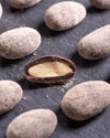 Close-up of chocolate-covered almonds on a dark surface