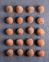 Pattern of coated hazelnut balls on a dark gray background