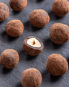 Close-up of coated hazelnuts on a dark surface