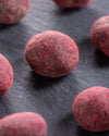 Close-up of chocolate covered raspberries on a dark surface