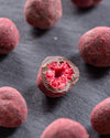 Close-up of a chocolate-dipped raspberries on a dark surface