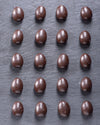 Pattern of chocolate candies on a dark surface