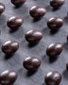 Dark chocolate beans on a dark surface