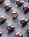 Close-up of chocolate-covered almonds on a dark surface
