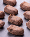 selection of chocolate truffles on dark stone surface