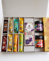 Inhalt der Geschenkbox Grand Deluxe: Schokoladen Tafel, Pralinen, Schokoriegel und Aufstriche. 