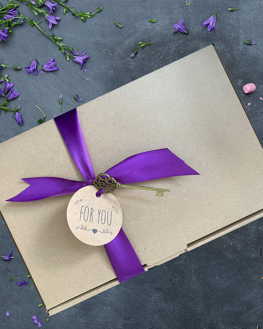 Geschenkbox mit Blumen im Hintergrund. 