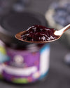 Marmeladenglas mit Fruchtaufstrich auf Löffel