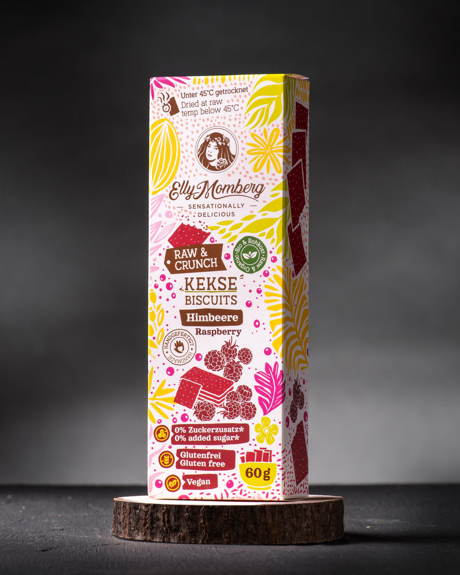 Bio Rohkost Kekse Himbeere ohne Zuckerzusatz und glutenfrei von Elly Momberg, Packung auf Holzuntersetzer 