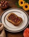 Toast mit Nussbutter und Haselnussbutter auf dem Brot. Mit Nüssen im Hintergrund. 