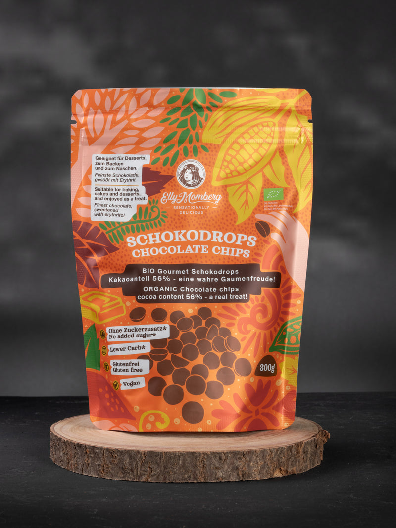 Bio Keto Schokodrops 56 Prozent mit Erythrit und Inulin von Elly Momberg, Packung auf Holzuntersetzer