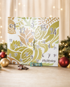 Veganer Adventskalender Deluxe 2026 mit 24 Überraschungen und 1500g vor festlichem Tannengrün